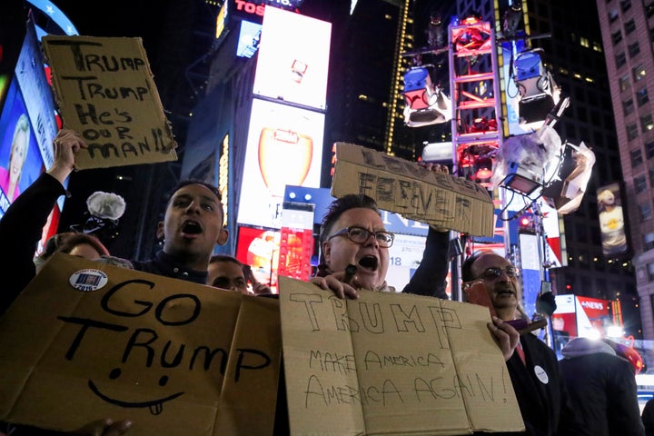 Supporters of U.S. President-elect Donald Trump hold signs as they rally in New York's Times Square on Nov. 9, 2016.