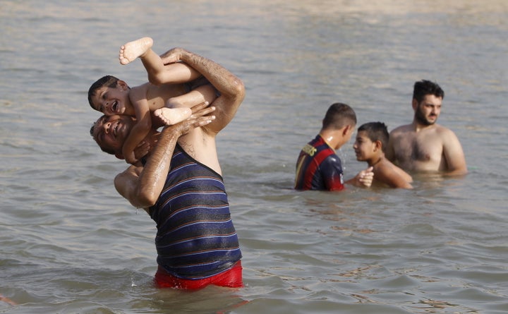 Residents play in the Tigris river to cool off in northern Baghdad's Adhamiya district July 30, 2015.