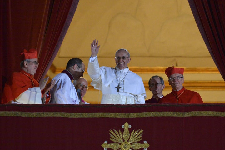 Pope Francis waves to the crowd from the central balcony of St. Peter's Basilica at the Vatican, during his first appearance just after being elected.