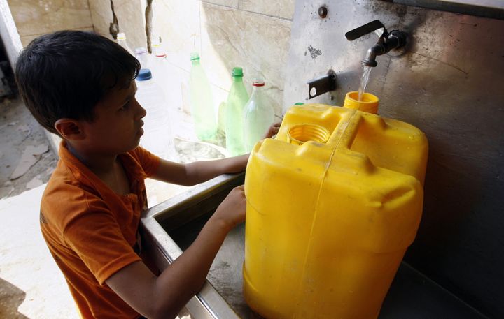 A Palestinian child fills his container in anticipation of water shortages in Rafah, Gaza Strip, on Aug. 28, 2014.