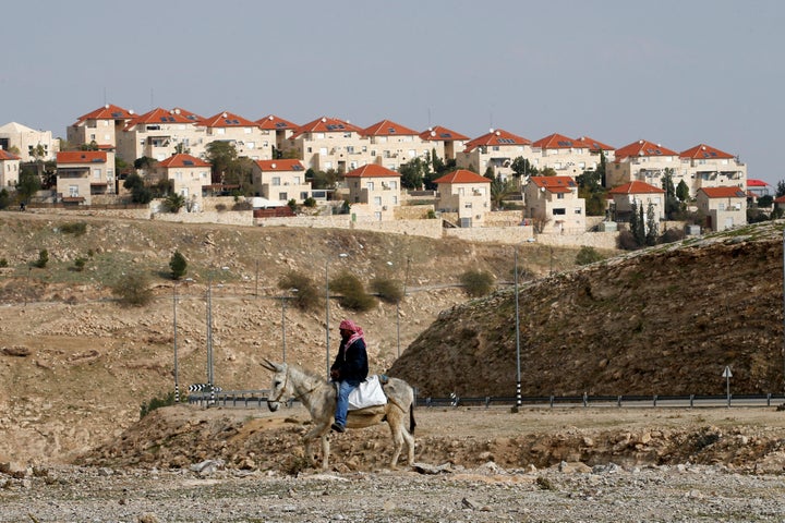 A Palestinian man passes an Israeli settlement in the West Bank on Dec. 28, 2016.