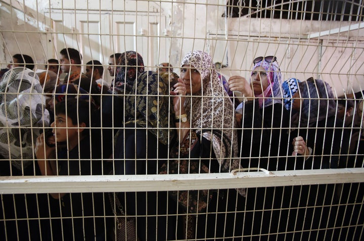 Palestinian Muslims wait at an Israeli checkpoint in Hebron, West Bank on July 1, 2016.