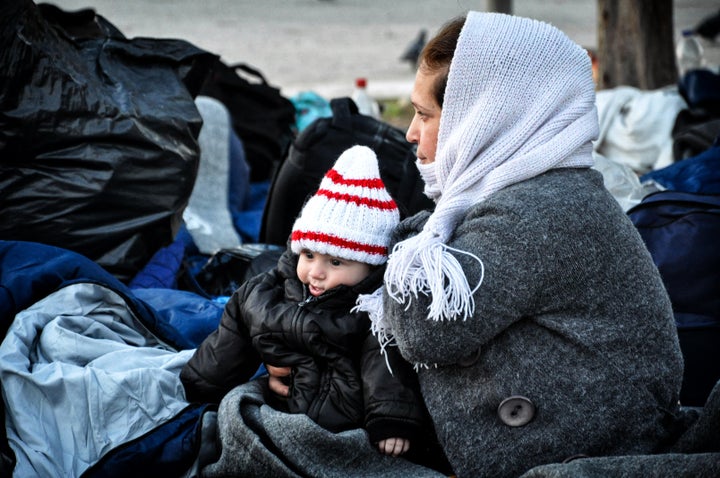 A Syrian refugee holds her baby at the Souda refugee camp on the island of Chios on November 20, 2016.