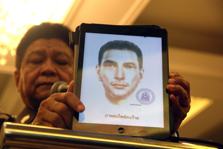 Thailand's national police spokesman Prawut Thavornsiri holds a tablet displaying a picture of an unnamed foreign man wanted by police in a bomb attack at the Hindu Erawan Shrine.