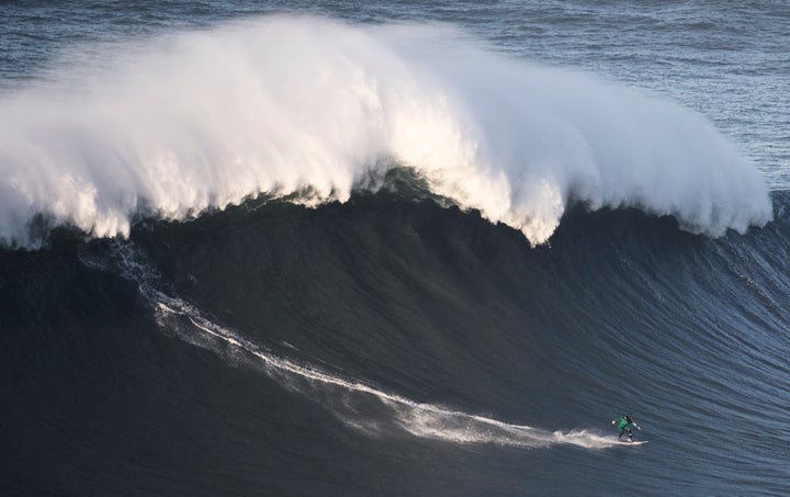 Andrew Cotton rides a wave during a December big wave competition at Praia do Norte in Nazare Portugal.