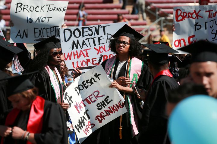 Protesters hold signs to raise awareness of sexual assault on campus at the Stanford University commencement ceremony in Palo Alto, California, June 12, 2016.