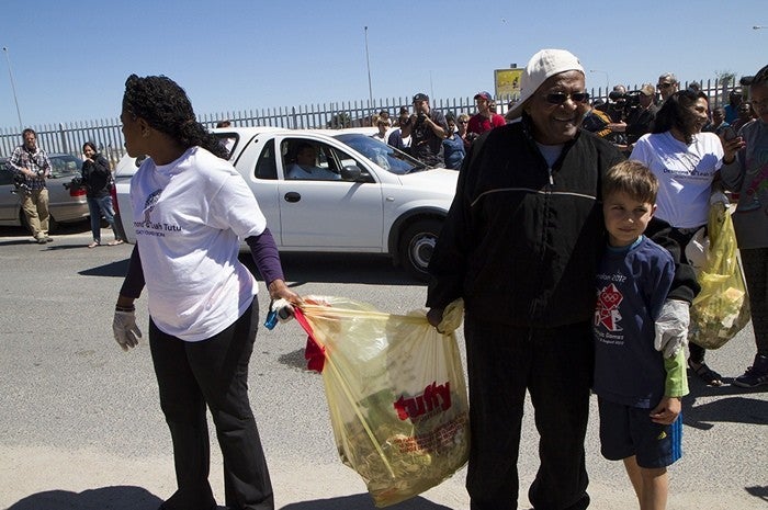 <p><em>Reverend Canon Mpho Tutu and the Archbishop are joined by young people to collect trash in one of the townships outside of Cape Town.</em></p>