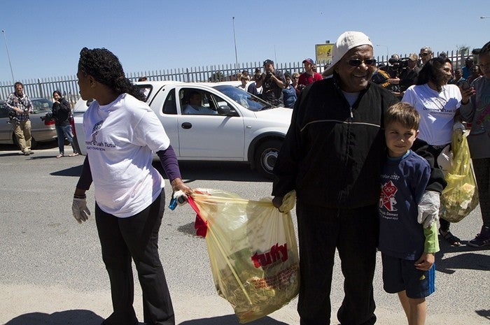 Reverend Canon Mpho Tutu and the Archbishop are joined by young people to collect trash in one of the townships outside of Cape Town.