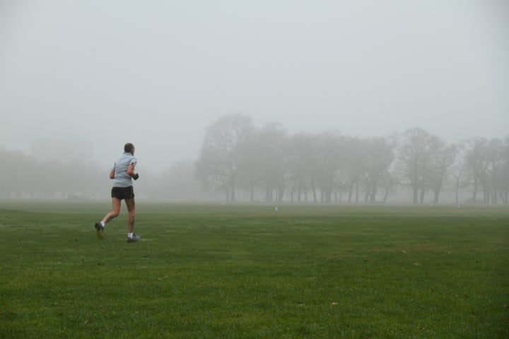 A jogger runs towards a grove of trees in Wanstead park yesterday