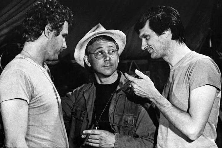 William Christopher, center, as Father Mulcahy on "M.A.S.H." surrounded by co-stars Wayne Rogers as Trapper John (left) and Alan Alda as Benjamin Franklin "Hawkeye" Pierce (right).