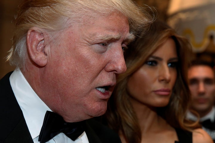 President-elect Donald Trump talks to reporters as he and his wife, Melania, arrive for a New Year's Eve celebration with mem