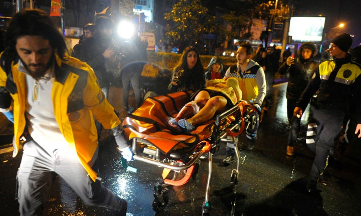 First aid officers carry an injured woman at the site of an armed attack on January 1, 2017 in Istanbul.