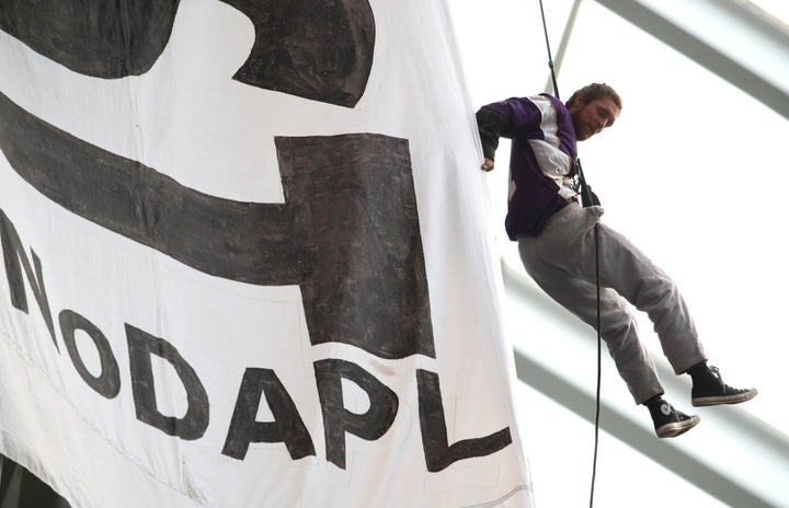 A Dakota Access Pipeline protester hangs from the ceiling of the U.S. Bank Stadium during the Minnesota Vikings and Chic