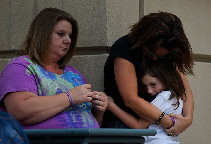 Heather Dearman, far right, and her daughter Aubry, 8, cousins of Aurora Theater shooting victim Veronica Moser-Sullivan, hug during a remembrance ceremony for the 4th anniversary of the Aurora Theater shooting on July 20, 2016 in Aurora, Colorado.