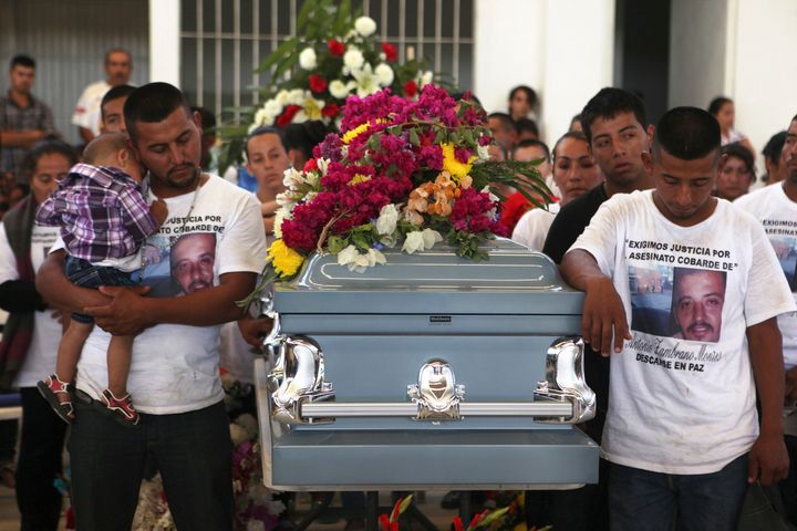 Relatives of Antonio Zambrano-Montes stand next to his coffin during a funeral mass in Pomaro, in the Mexican state of Michoacan March 7, 2015.