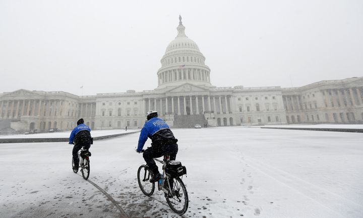 Police on mountain bikes patrol in the snow in front of the U.S. Capitol in Washington January 21, 2014.
