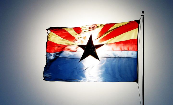 The setting sun illuminates the state flag of Arizona in this undated Getty file photo.