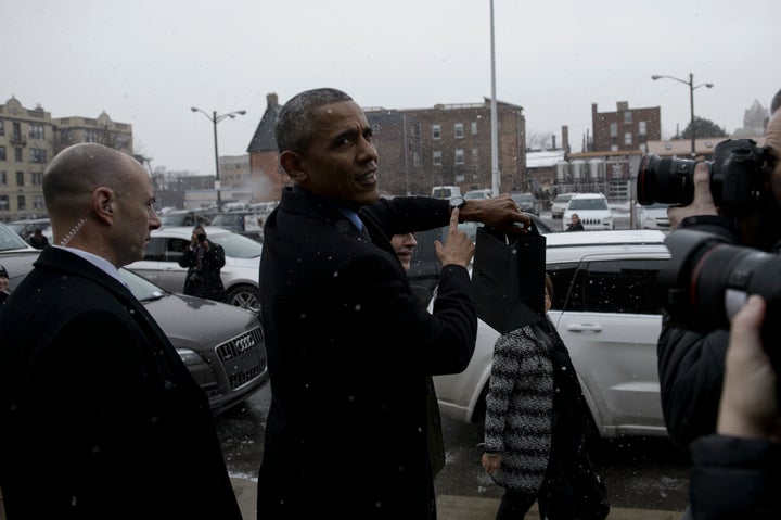 US President Barack Obama points to his Shinola watch, which he already owned, after visiting a Shinola store January 20, 2016 in Detroit, Michigan.