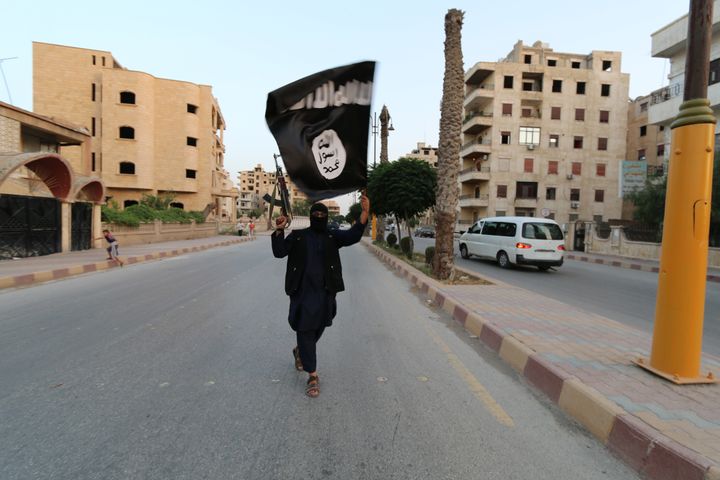 A member loyal to the Islamic State in Iraq and the Levant (ISIL) waves an ISIL flag in Raqqa June 29, 2014.
