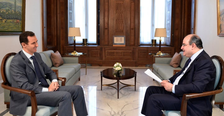 Syria's President Bashar al-Assad (L) attends an interview with al-Watan newspaper in Damascus, Syria, in this handout pictur