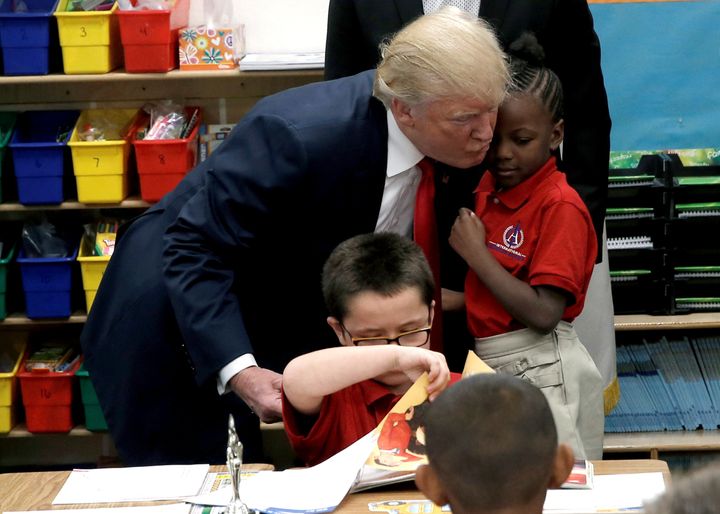 Republican presidential nominee Donald Trump hugs a student after receiving a bible as a gift during a campaign visit to International Christian Academy in Las Vegas, Nevada, October 5, 2016.