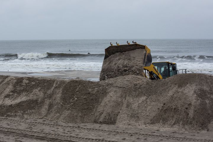 A bulldozer builds sand berms in Long Beach, New York.