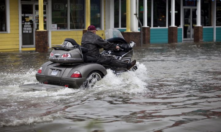 A cyclist navigates through floodwaters in Garden City Beach, South Carolina.