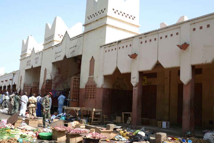 Soldiers and police forces stand guard among dead bodies at a market in N'Djamena following a suicide bomb attack.