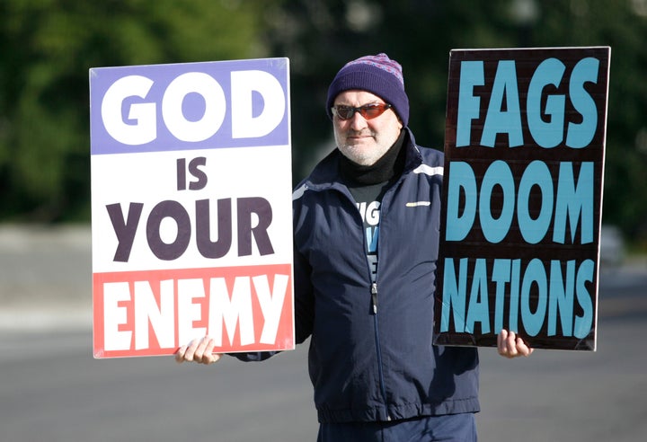 Fred Phelps Jr., a member of Westboro Baptist Church, holds up anti-gay signs while protesting the Supreme Court in 2010. The signs are similar to those at Matthew Shepard's funeral.