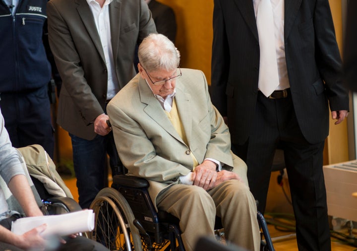 The 94-year-old former Auschwitz guard is seen being wheeled into a courtroom in Detmold, Germany.