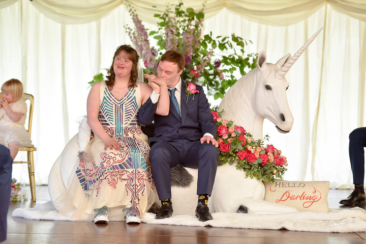 The newlyweds sitting atop their unicorn throne.