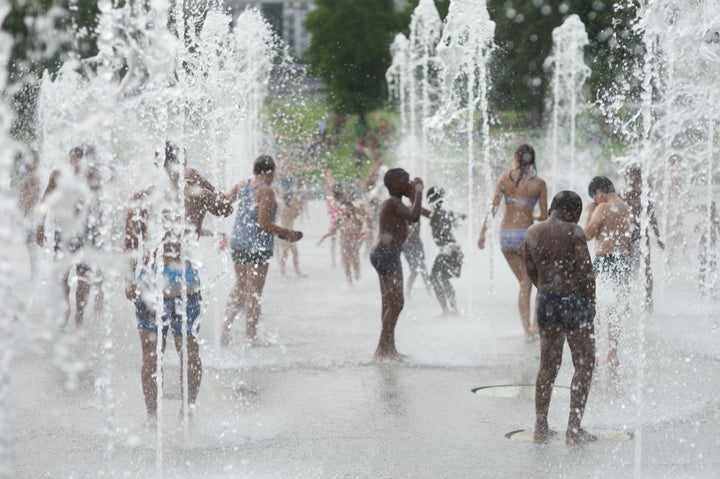 As temperatures soared to 100 degrees Fahrenheit during the Paris heat wave in August 2016, children cooled off in a fountain in Parc Andre Citroen.