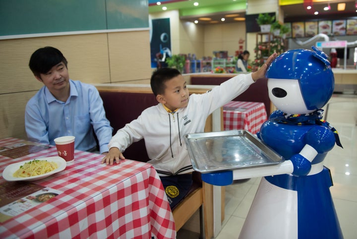 Robot waiters working at a robot restaurant. Kunshan, China. May 22, 2016.