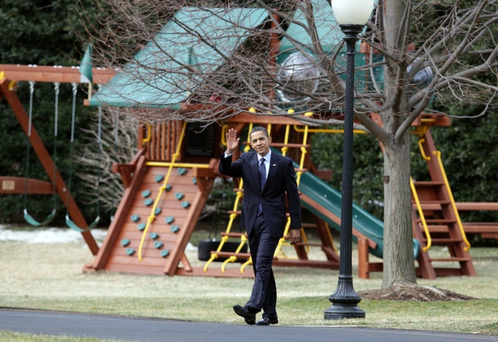 President Barack Obama walks past his daughters’ swing set shortly after it was installed in 2009.