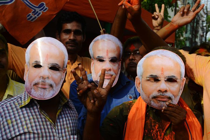 Indians wear masks bearing Modi's image as they celebrate the BJP's election result. Siliguri, India. May 16, 2014.