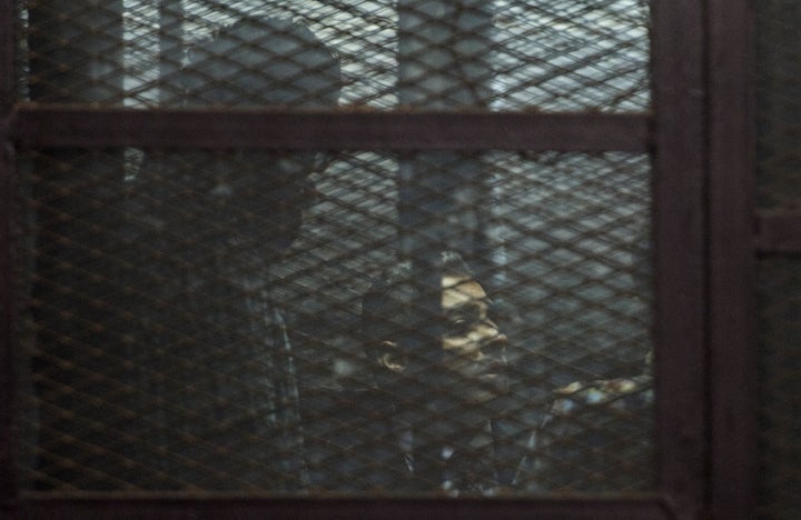 Al-Jazeera journalists, Canadian Mohamed Fahmy (C) and Egyptian Baher Mohamed (unseen), both accused of supporting the blackl