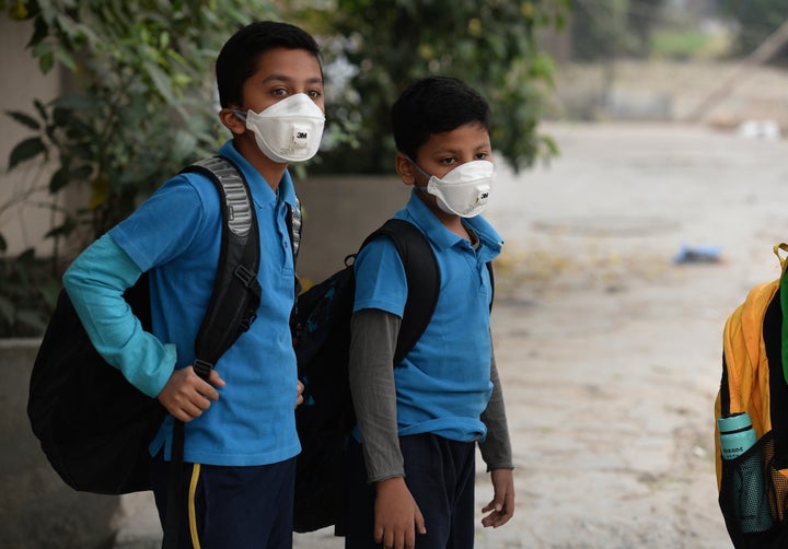 ndian school children wear masks as they wait for the bus as schools re-open after three days of closure due to smog, in New Delhi on November 10, 2016.