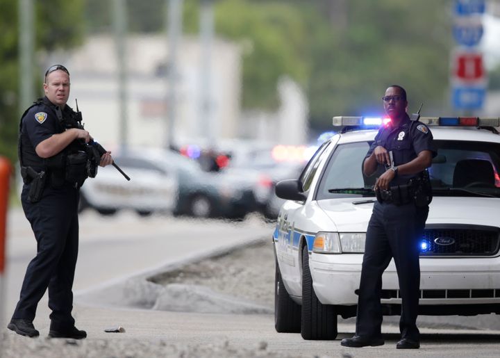 Police officers stand on the perimeter road along the Fort Lauderdale-Hollywood International Airport