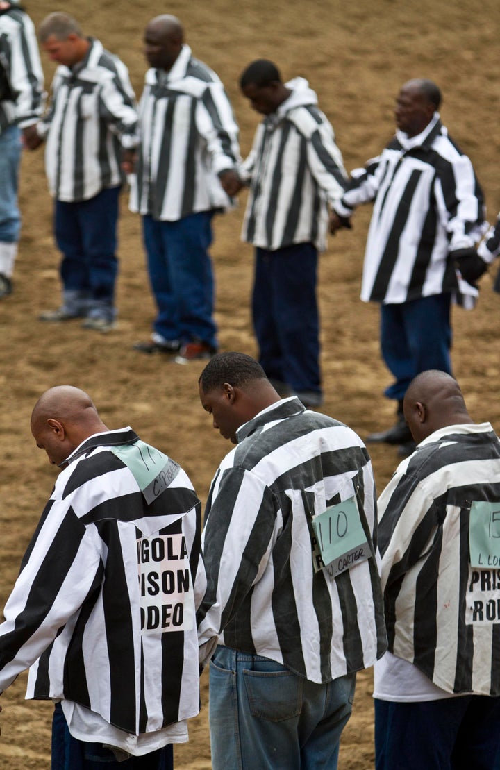 Inmates hold hands during a prayer at the Angola Rodeo.