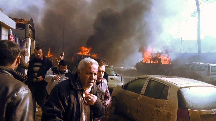 An image grab taken from an AFPTV video released on January 7, 2017 shows people gathering amidst the debris at the site of a car bomb attack in the rebel-held town of Azaz in northern Syria. According to the Syrian Observatory for Human Rights, at least 43 people were killed and dozens injured in the blast that ripped through the town near the Turkish border.