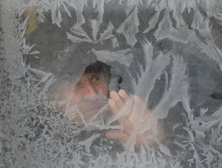 A man looks through a frosted bus window with the air temperature at about minus 16 degrees Celsius (3.2 degrees Fahrenheit), in Lviv, Ukraine January 6, 2017.