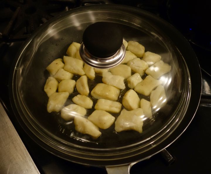 Covered, the frozen gnocchi will heat through in steam before they start to brown