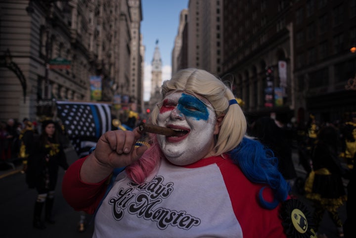 A reveler smokes a cigar as he poses for a photo in fancy dress during the annual Mummers Parade in Philadelphia. The annual event has long been associated with offensive skits and costumes.