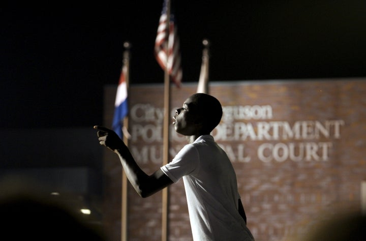 A protester yells at police stationed outside the police department in Ferguson, Missouri, on Aug. 8, 2015. The shooting death of Michael Brown in Ferguson raised the profile of the Justice Department's work on policing issues.