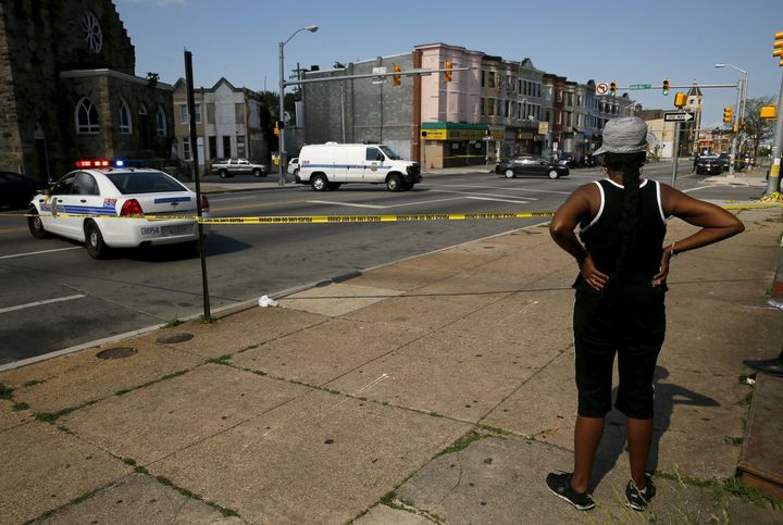 A resident in the neighborhood where Freddie Gray was arrested and where residents rioted over his death in April look on at the scene of a shooting at the intersection of West North Avenue and Druid Hill Avenue in West Baltimore, Maryland.