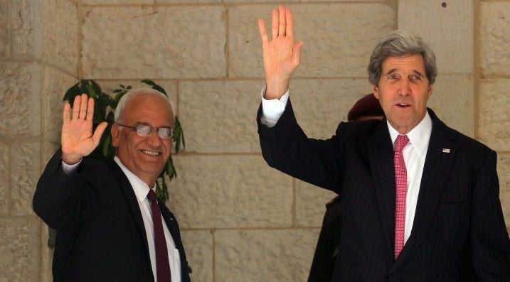 <p>U.S. Secretary of State John Kerry (R) and Palestinian chief negotiator Saeb Erekat (L) wave before a meeting with Palestinian Authority President Mahmoud Abbas at the presidential compound in Ramallah January 4, 2014.</p>