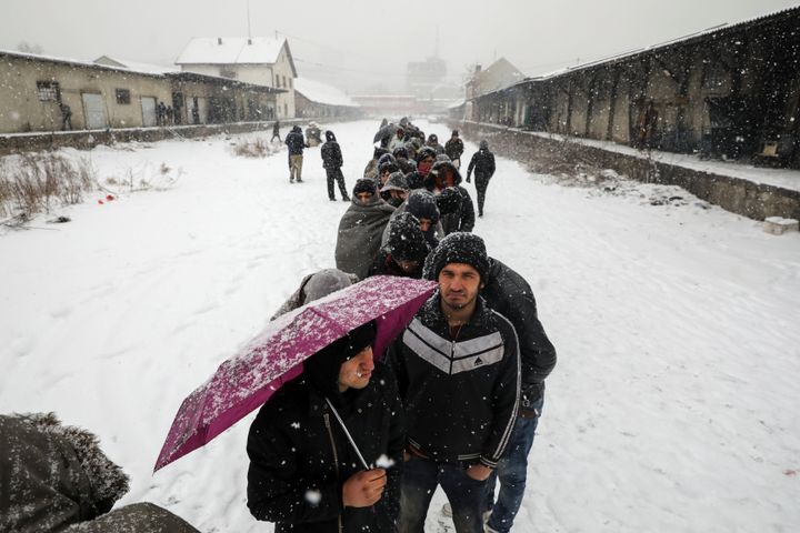 Migrants wait in line to receive free food during a snowfall outside a derelict customs warehouse in Belgrade, Serbia January 9, 2017.