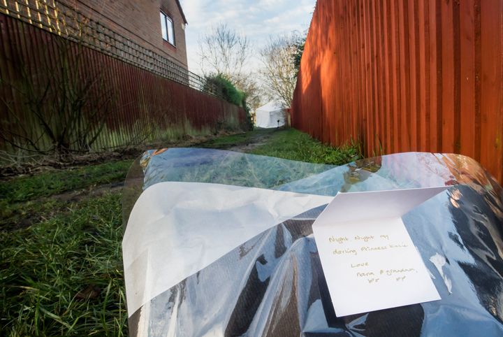 A card, identifying the victim as 'Katie' is left with a floral tribute at the scene 