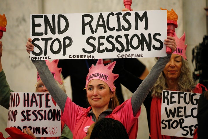 Protesters take positions at the start of a Senate Judiciary Committee confirmation hearing for U.S. Attorney General-nominee