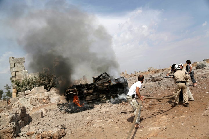 Civil defense members extinguish a military vehicle at a base controlled by rebel fighters from the Ahrar al-Sham Movement, that was targeted by what activists said were Russian airstrikes in the south of Idlib province, Syria October 1, 2015.